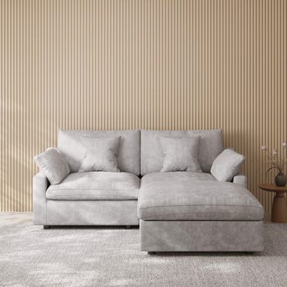 Light gray sectional chaise lounge sofa in a room with striped wallpaper
