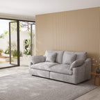 Gray loveseat sofa in a modern living room with a striped wall and glass door.