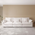 White 3-seater sofa in a living room with a striped wall and rug.