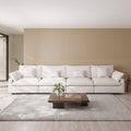 White 4-seat sofa in a modern living room with a wooden coffee table and decorative elements.