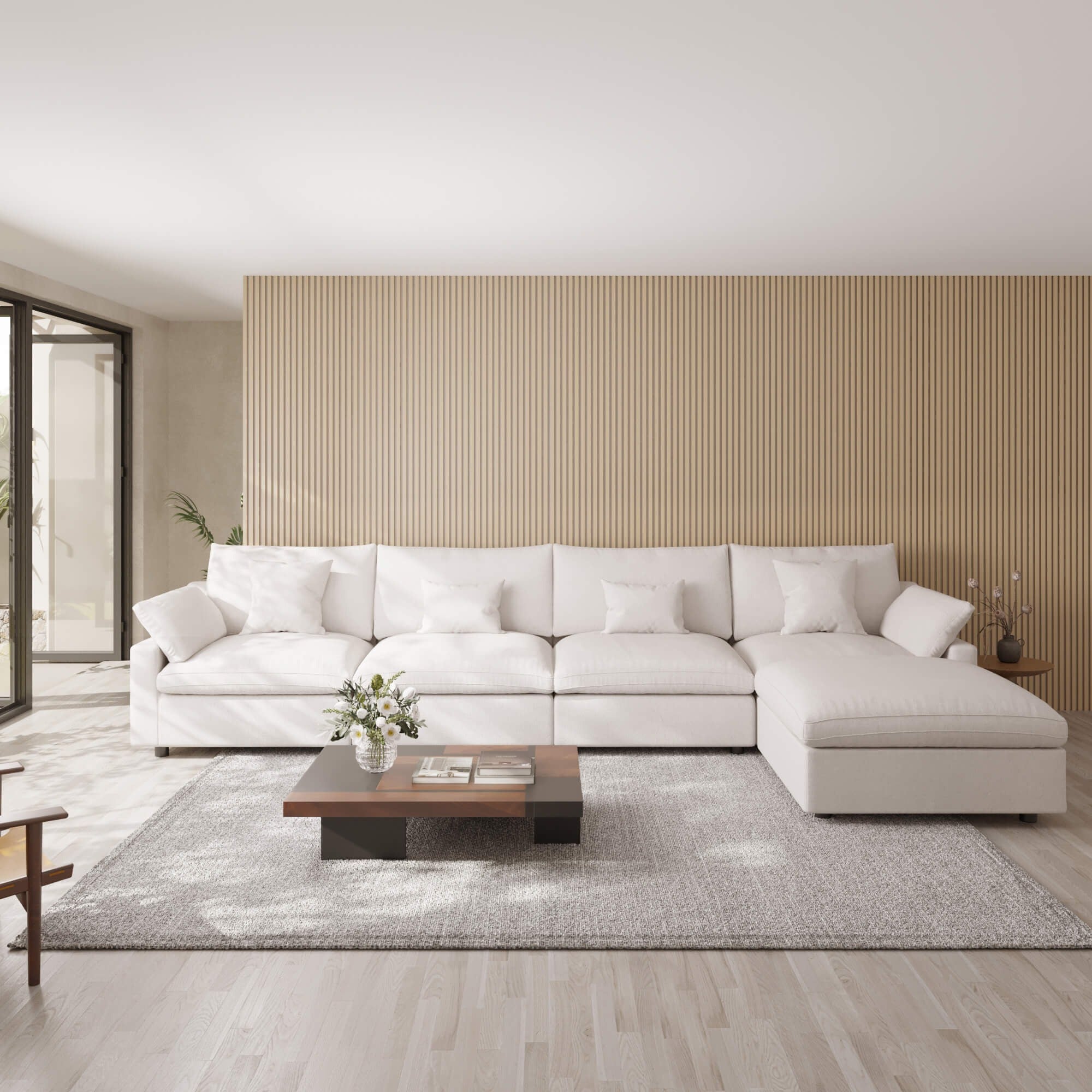 Modern living room with a white 5-seat sectional sofa with ottoman, wooden coffee table, and striped wall.