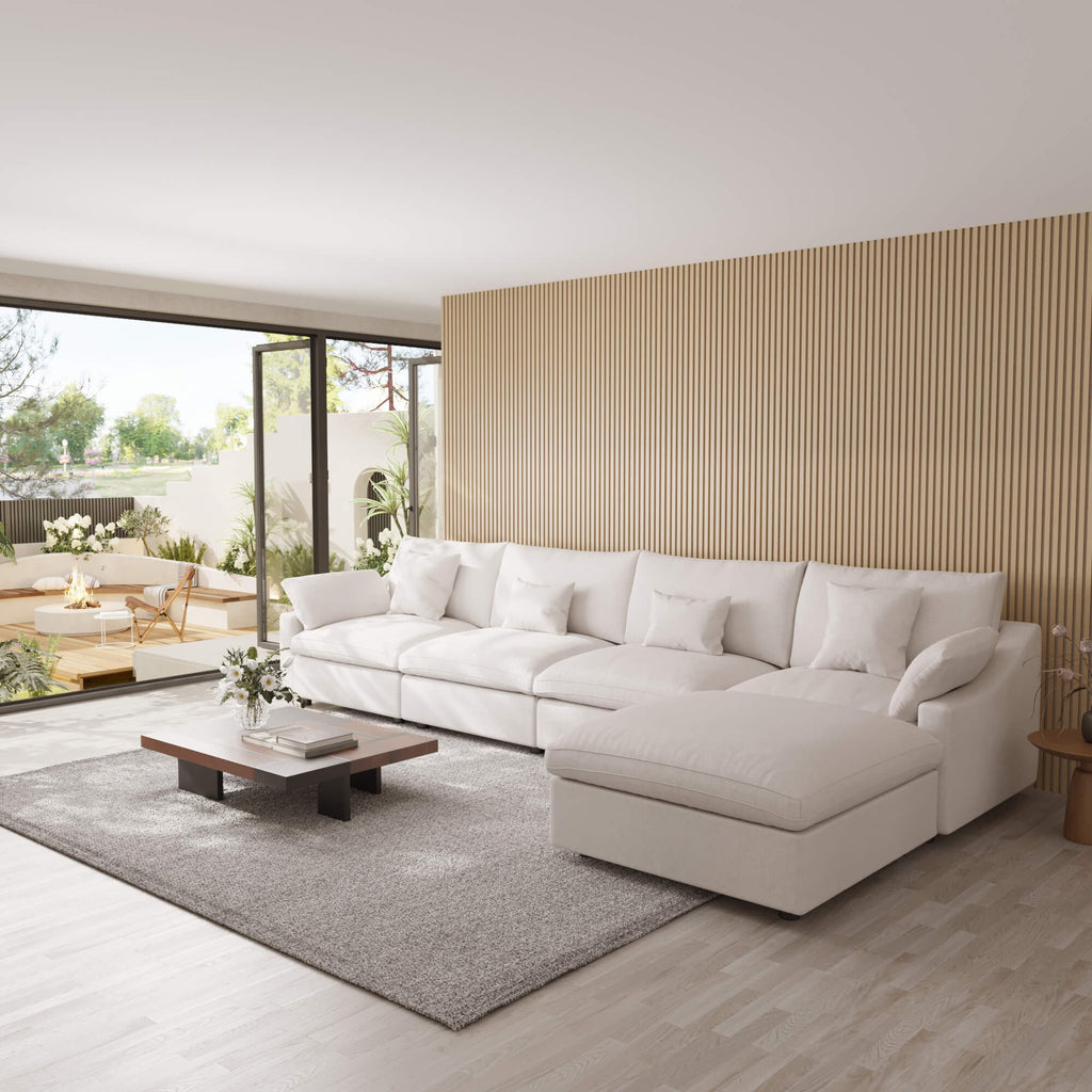 Modern living room with a large white 5-seat sectional sofa with ottoman, coffee table, and decorative elements.