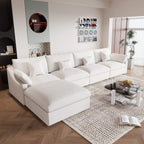 A large, white washable cloud sectional 5-seat sofa with removable cushions and an ottoman, placed in a living room setting.