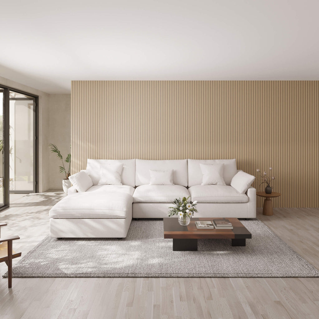 Modern living room with a white L-shaped sectional sofa, wooden coffee table, and decorative elements.