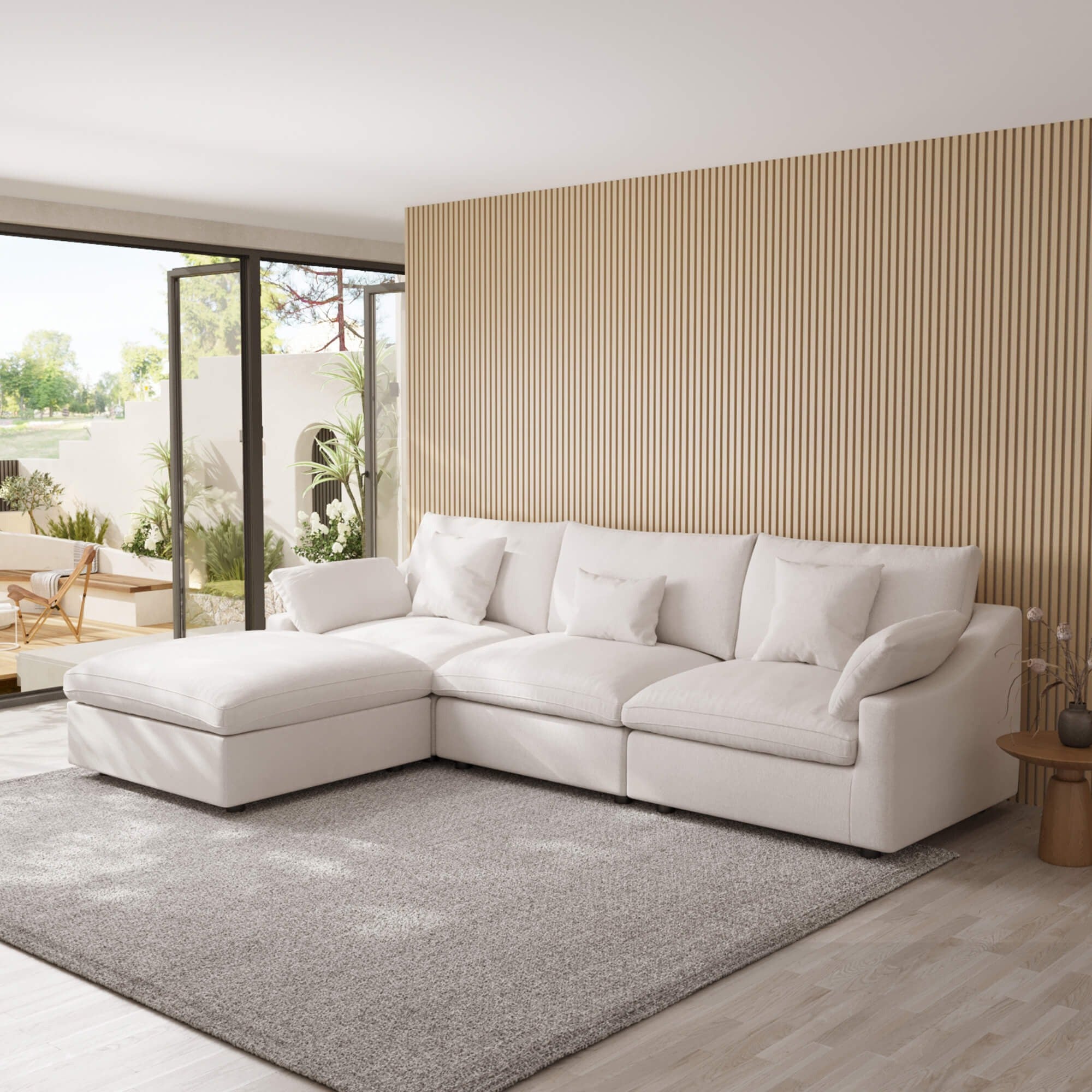 White L-shaped sectional sofa in a modern living room with a striped wall and sliding glass doors.