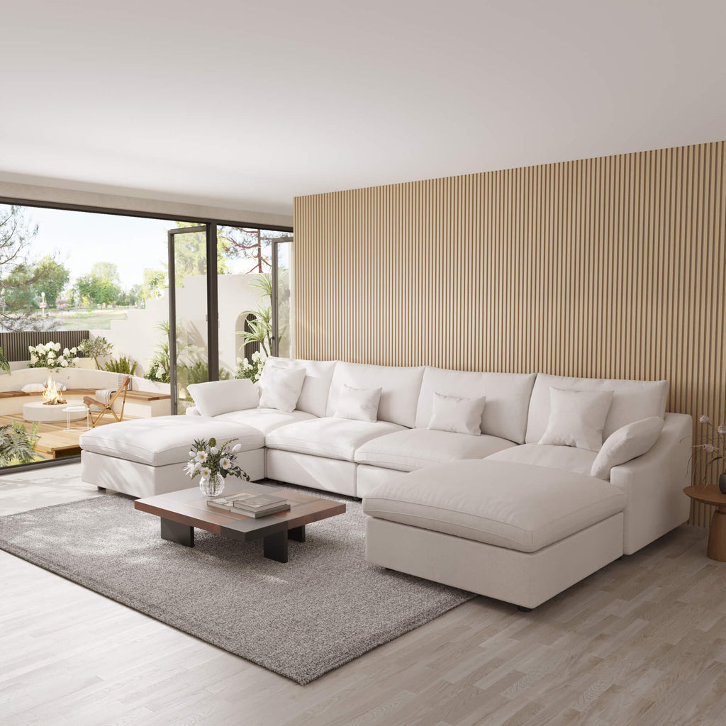 Modern living room with a white U-shaped sectional sofa, wooden coffee table, and decorative elements.