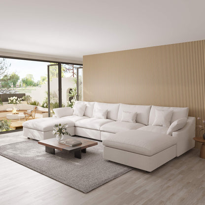 Modern living room with a white U-shaped sectional sofa, wooden coffee table, and decorative elements.