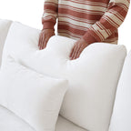 Person pressing on a backrest cushion of a white sofa to show its softness