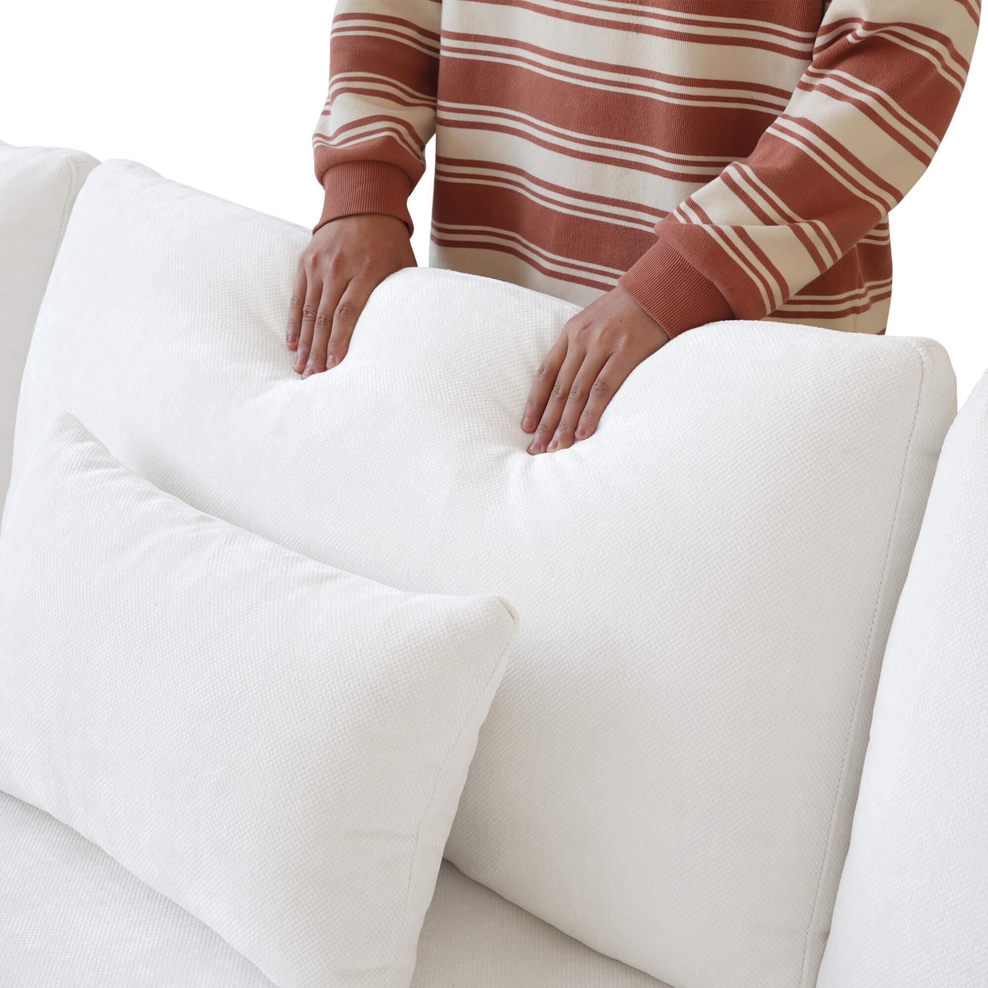 Person pressing on a backrest cushion of a white sofa to show its softness