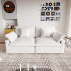 A white loveseat sofa, featuring a minimalist design with removable cushions, placed in a room with modern decor.