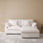 White sofa with a chaise lounge against a beige wall.