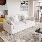A white loveseat sofa, featuring a minimalist design with removable cushions, placed in a room with modern decor.