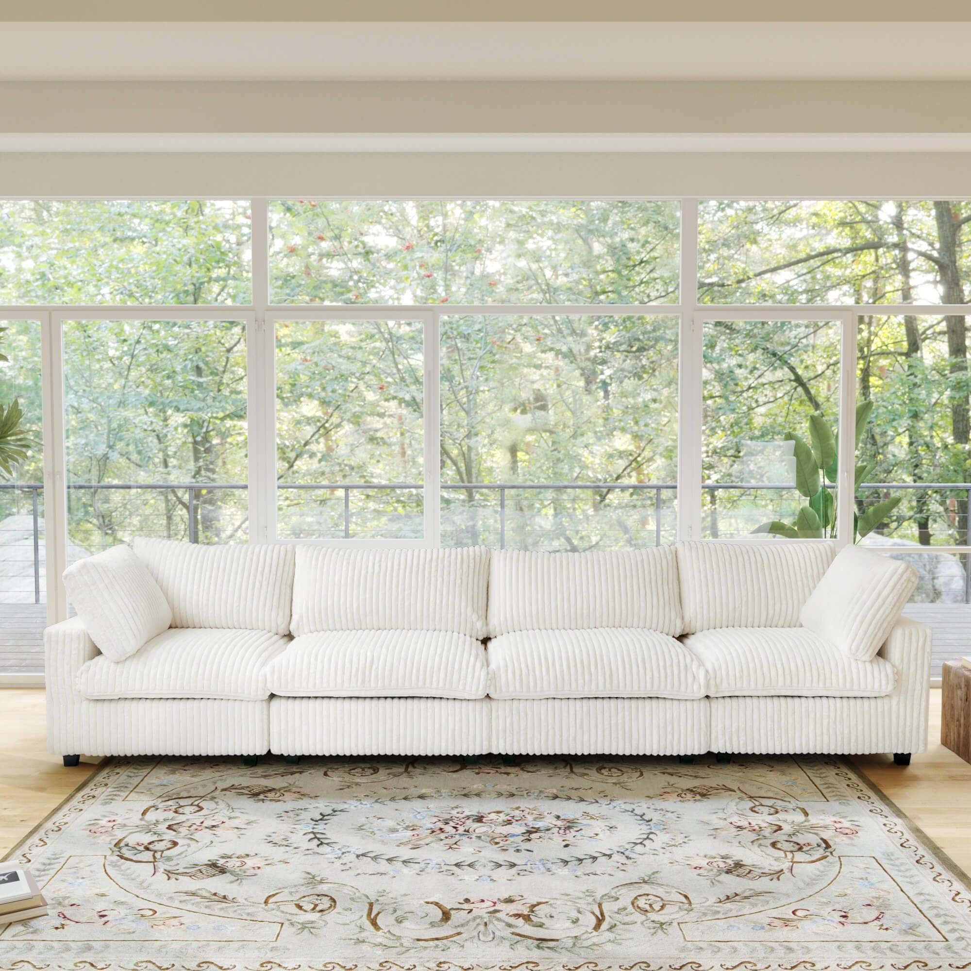 Beige faux rabbit fur 4-seat sofa in a room with large windows and a view of trees.