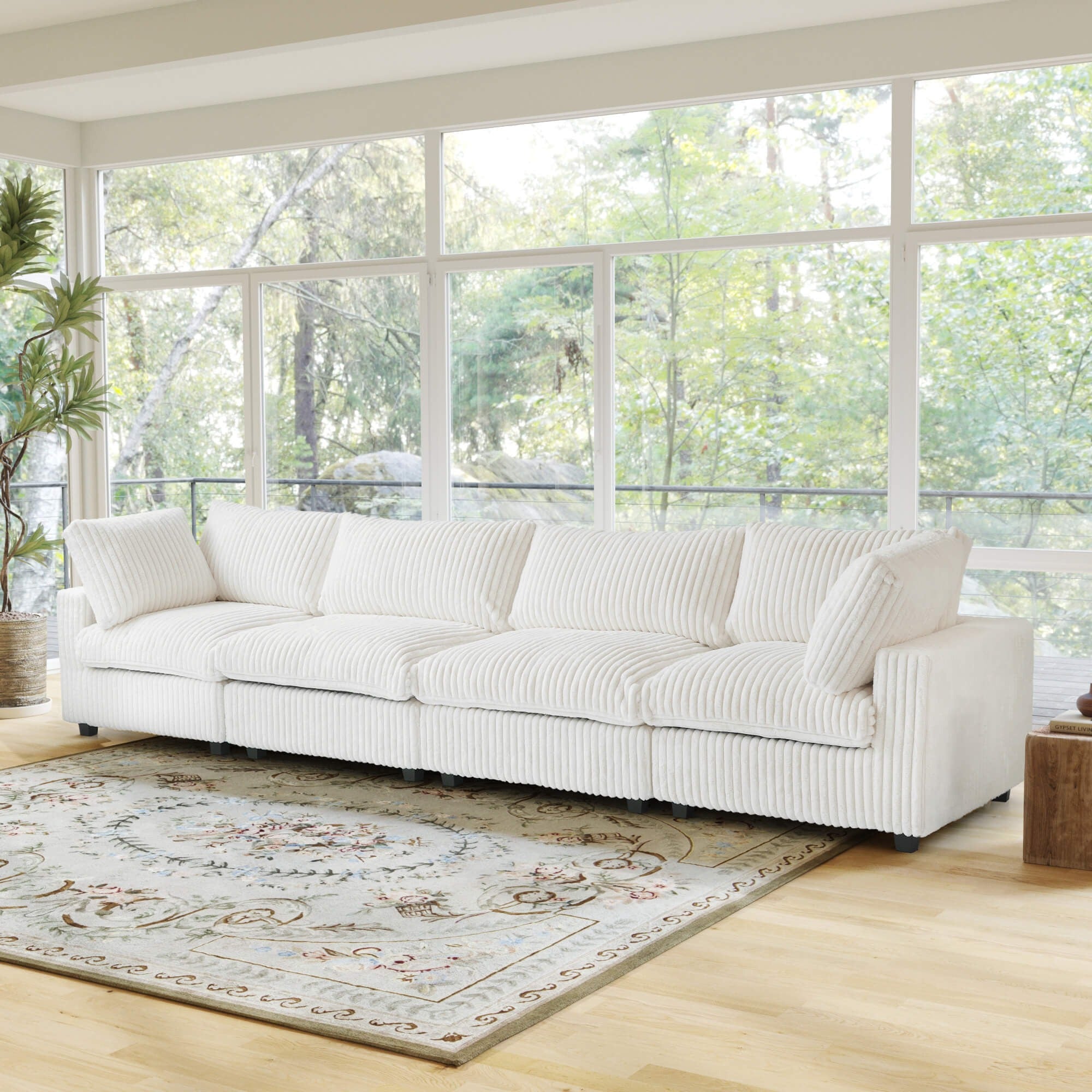 Beige faux rabbit fur 4-seat sectional sofa in a room with large windows and a rug.