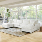 Beige U-shaped sectional sofa in a living room with large windows and a rug.