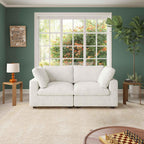 A white faux rabbit fur 2-seater sofa with removable covers, positioned in a room with green walls, a large window, and a wooden floor.