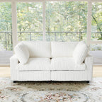 White faux rabbit fur sofa in a room with large windows showing greenery outside.