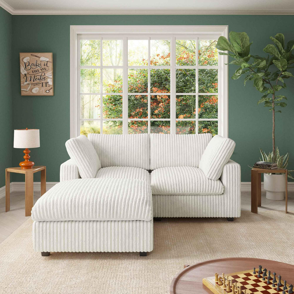 A white faux rabbit fur loveseat and ottoman, placed in a room with green walls, a large window, and a striped pattern.