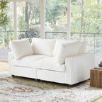 White faux rabbit fur sofa in a room with large windows and a decorative rug.