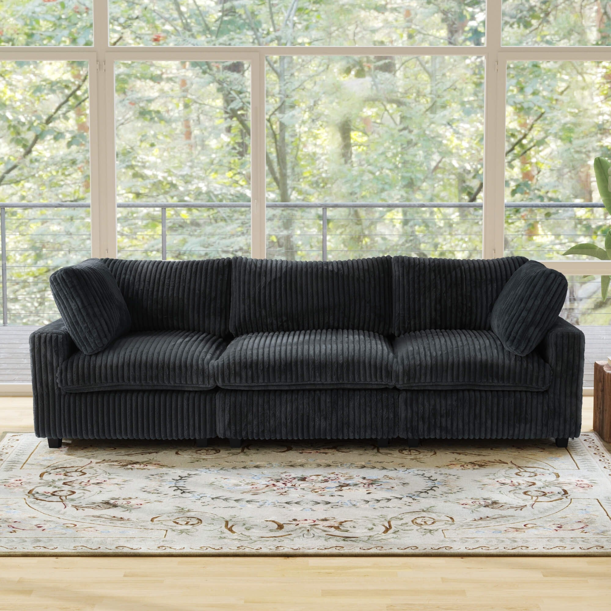 Black faux rabbit fur 3-seat sofa in a room with large windows and a decorative rug.