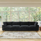 Black faux rabbit fur 4-seat sofa in a living room with large windows and greenery outside