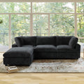 Black L-shaped sectional sofa in a room with large windows and a rug.