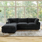 Black L-shaped sectional sofa in a room with large windows and a rug.
