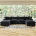 Black U-shaped sectional sofa in a living room with large windows and greenery outside