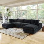 Black U-shaped sectional sofa in a living room with large windows and a rug.