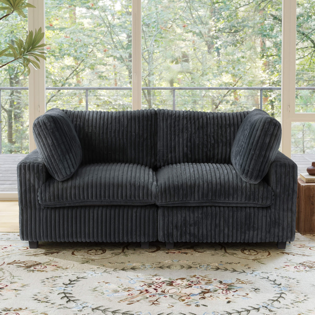 Black faux rabbit fur loveseat sofa in a room with large windows and a floral rug