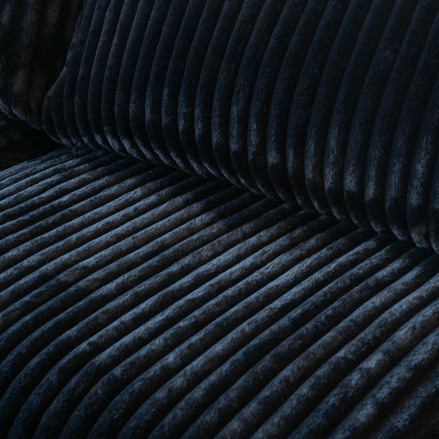 Close-up of a seat of a black faux rabbit fur sofa