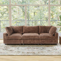 Brown faux rabbit fur 3-seat sofa in a room with large windows and a decorative rug.