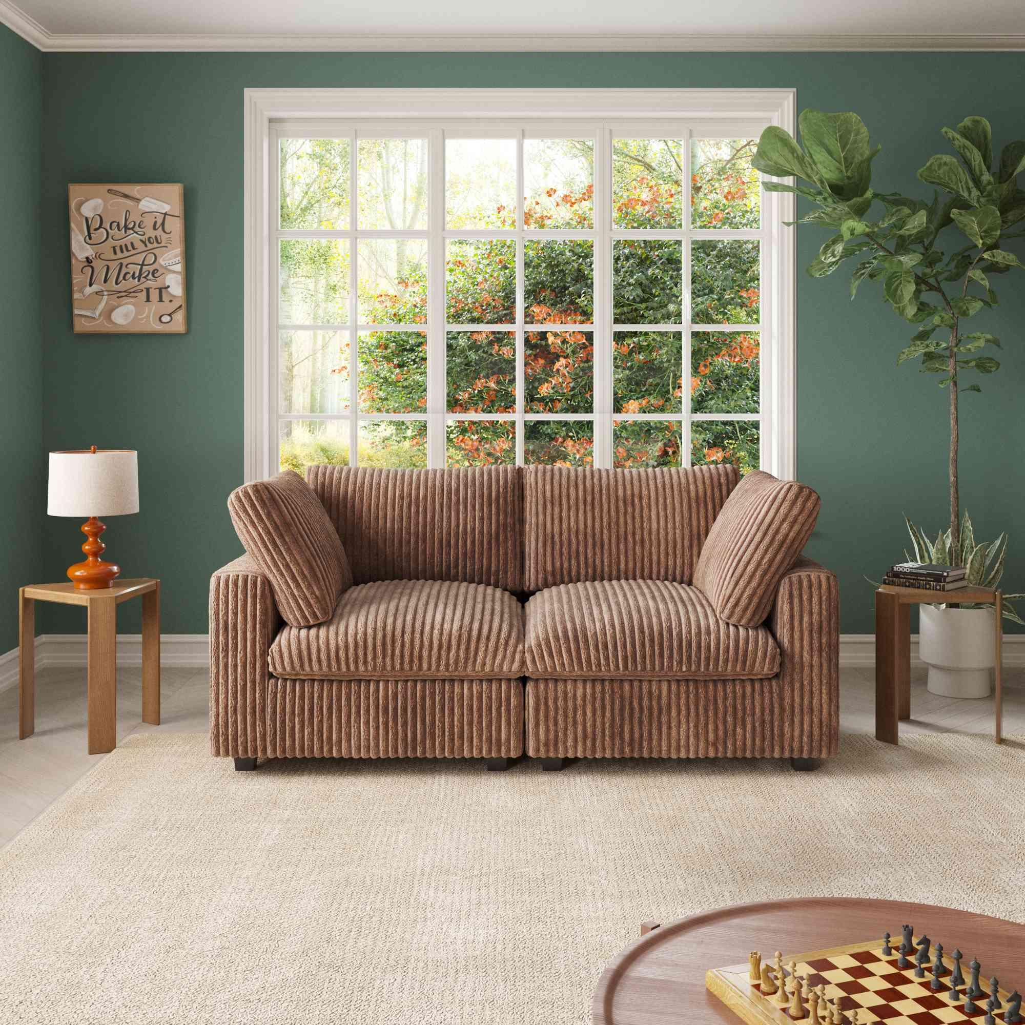 A brown faux rabbit fur loveseat sofa with removable covers, positioned in a room with green walls, a large window, and a wooden floor.