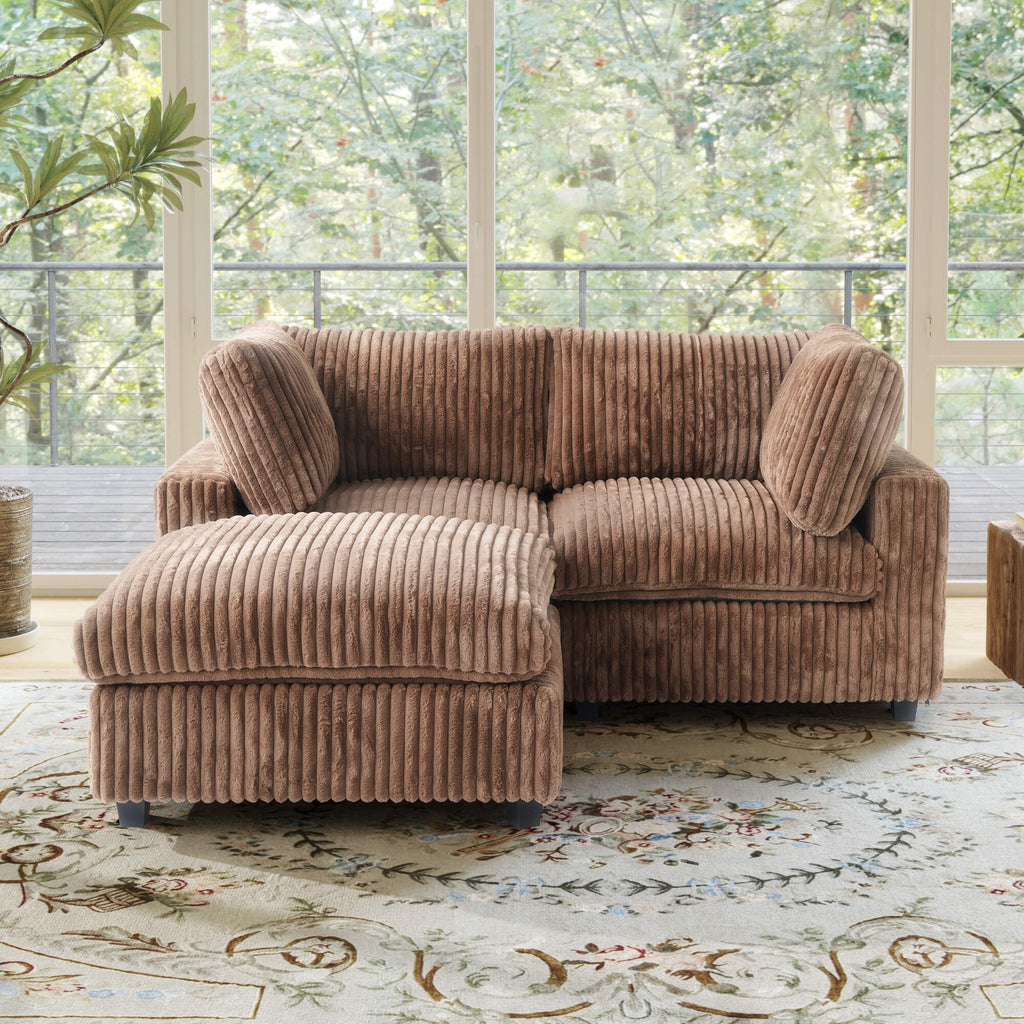 Brown faux rabbit fur sectional loveseat sofa with ottoman in a room with large windows and a decorative rug.