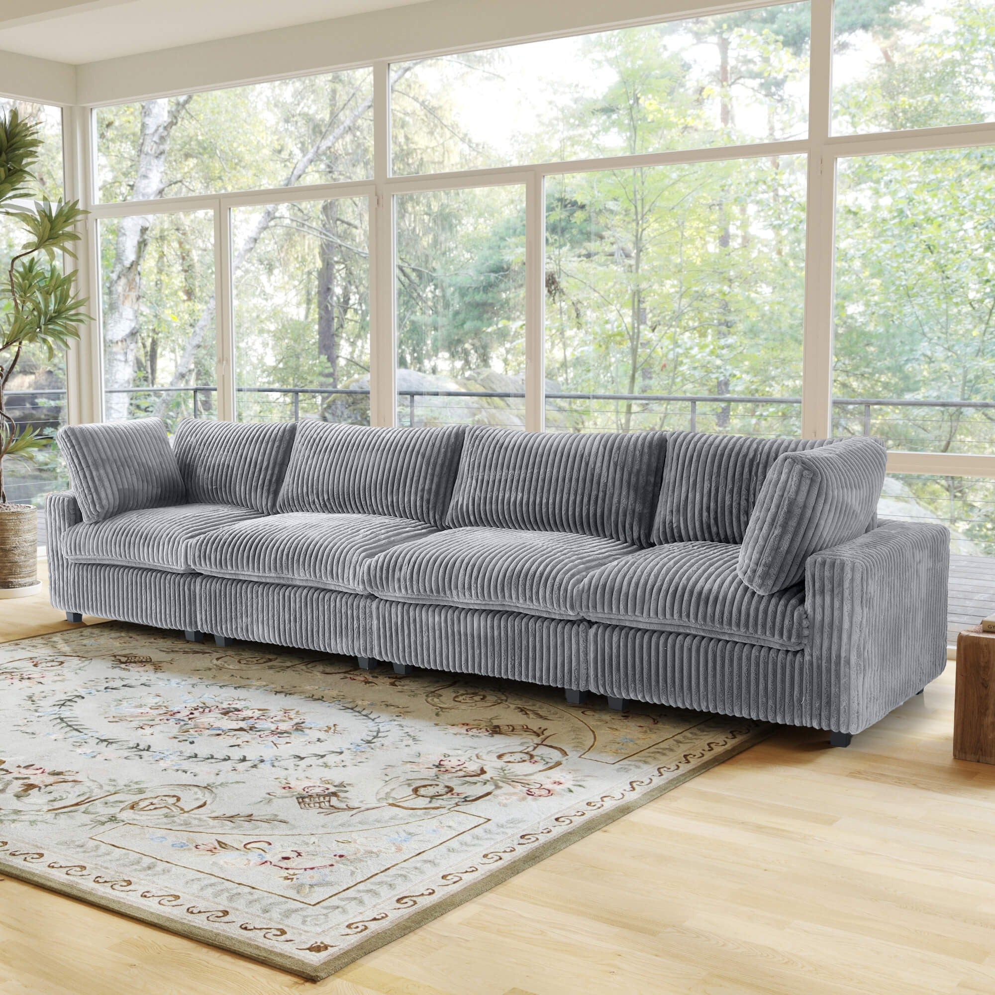 Gray faux rabbit fur 4-seat sofa in a living room with large windows and a rug.