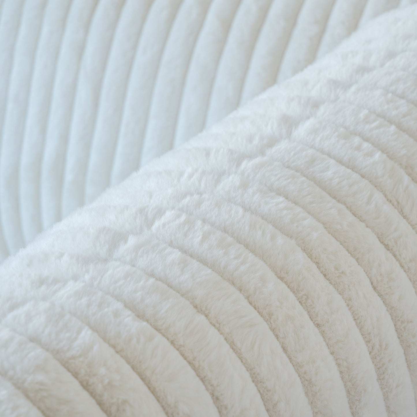 Close-up of a faux rabbit fur fabric of a white sofa