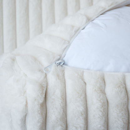 Close-up of an unzipped cover of a white faux rabbit fur sofa