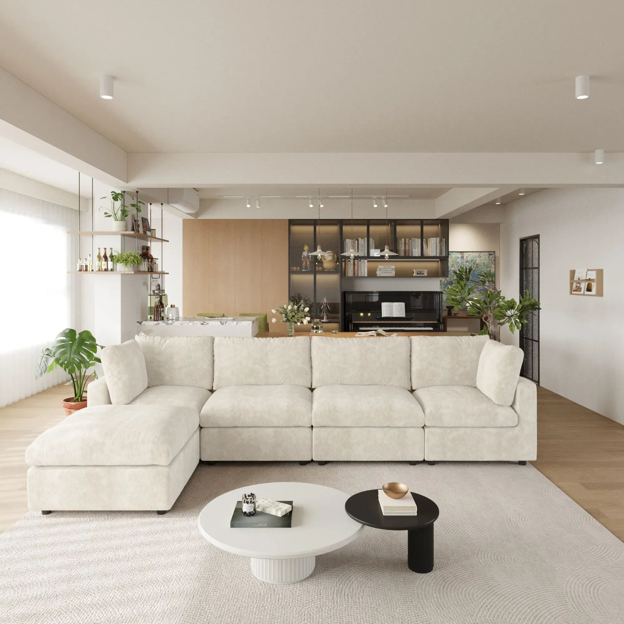 Modern living room with a beige L-shaped 5-seater sectional sofa, coffee table, and kitchen in the background.