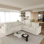 Modern living room with a beige 5-seater corner sectional sofa, coffee table, and kitchen in the background.