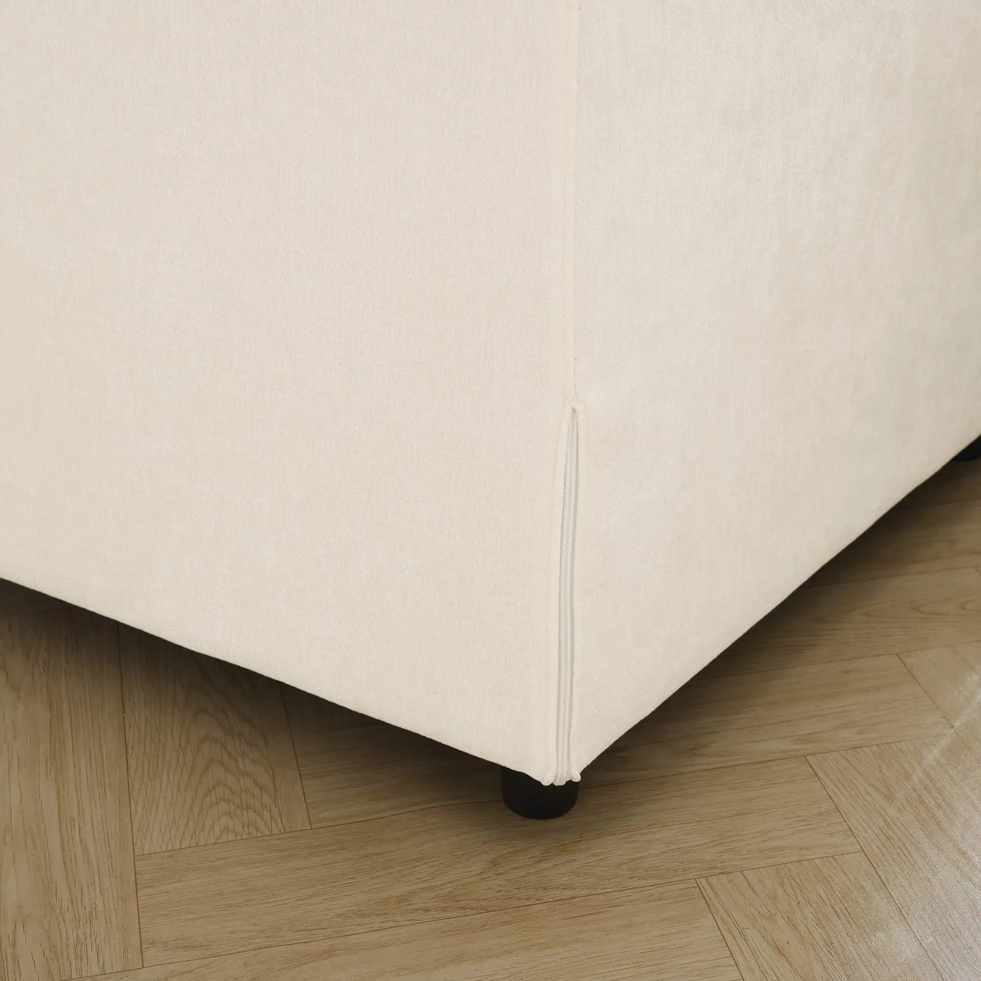 Beige upholstered sofa frame corner on a wooden floor