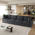 Modern living room with a black 4-seater sectional sofa, coffee table, and kitchen in the background.