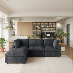 Black L-shaped 4-seater sectional sofa in a modern living room with kitchen in the background