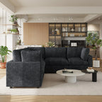 Modern living room with a black 5-seater corner sectional sofa, coffee table, and decorative items.