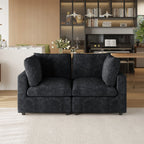 Black sofa in a living room with a bookshelf and piano in the background