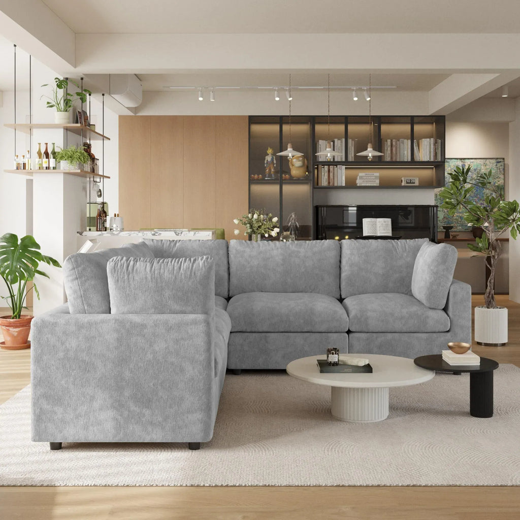 Gray 5-seater corner sectional sofa in a modern living room with decor elements.