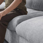 Person sitting on a gray sofa with a focus on the fabric texture.
