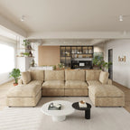Modern living room with khaki U-shaped 6-seater sectional sofa, coffee table, and kitchen in the background.