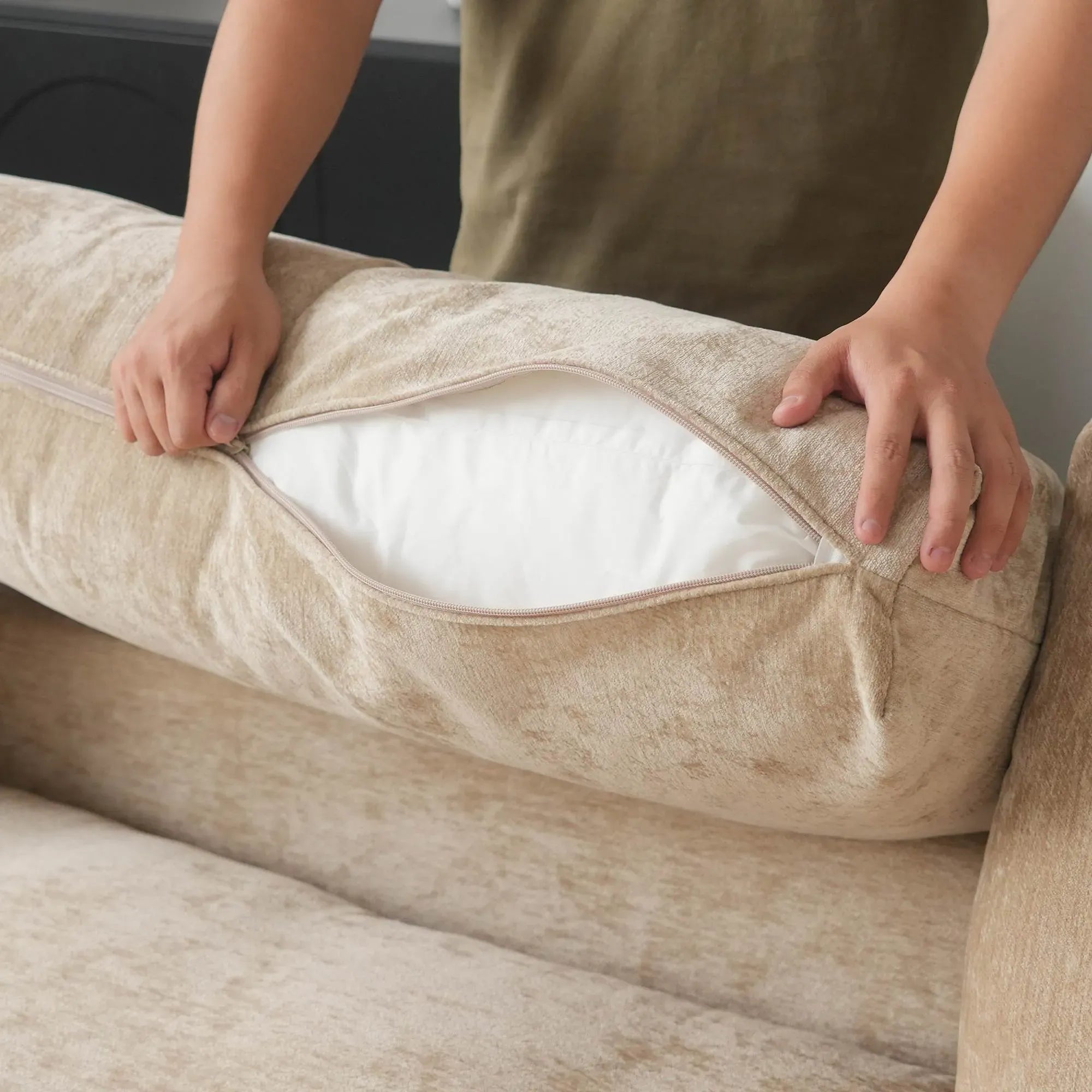 Person opening a khaki slipcover on a sofa to reveal the inner foam core.