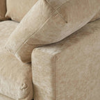 Close-up of a khaki sofa with visible texture and stitching.
