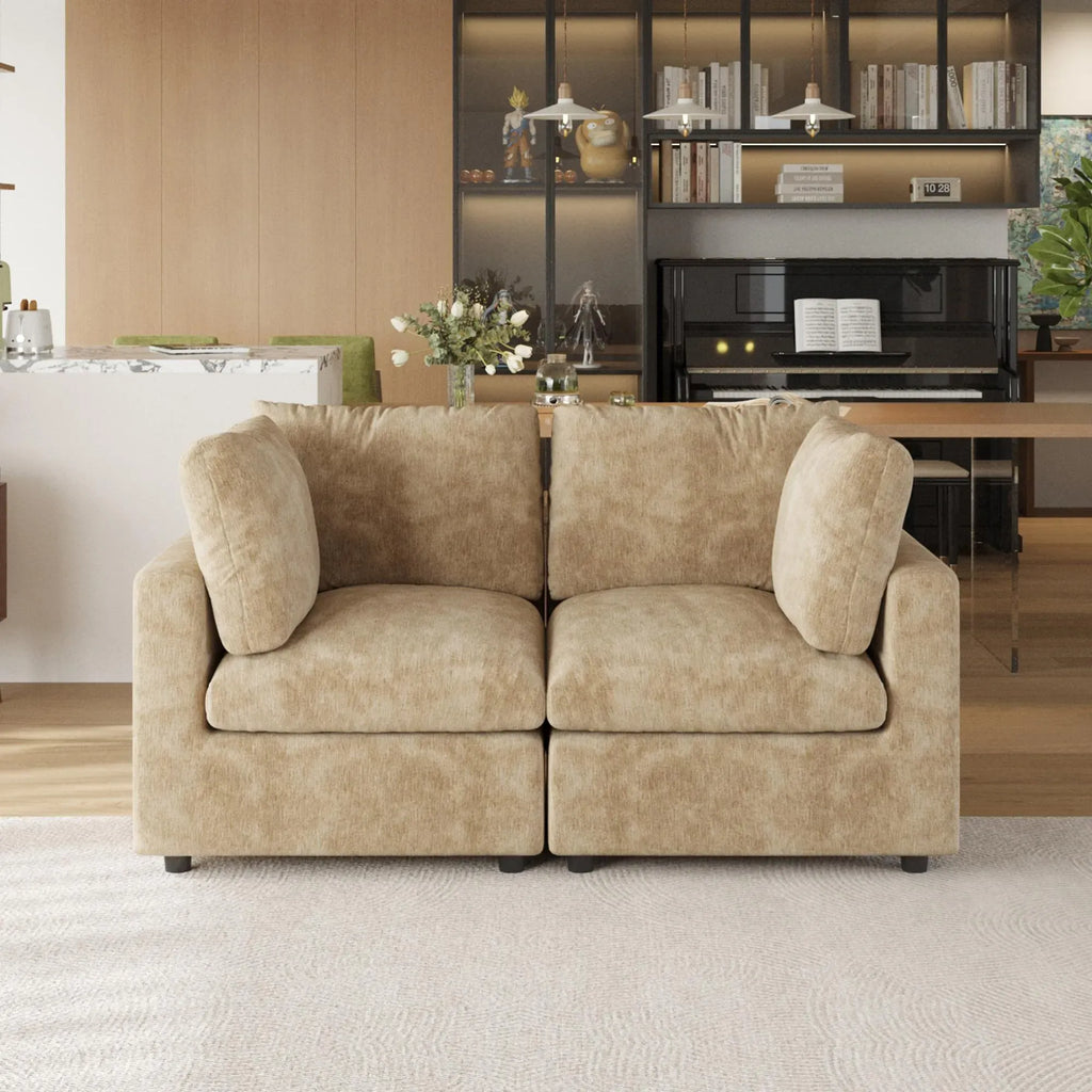 Khaki sofa in a living room setting with a piano and bookshelf in the background.